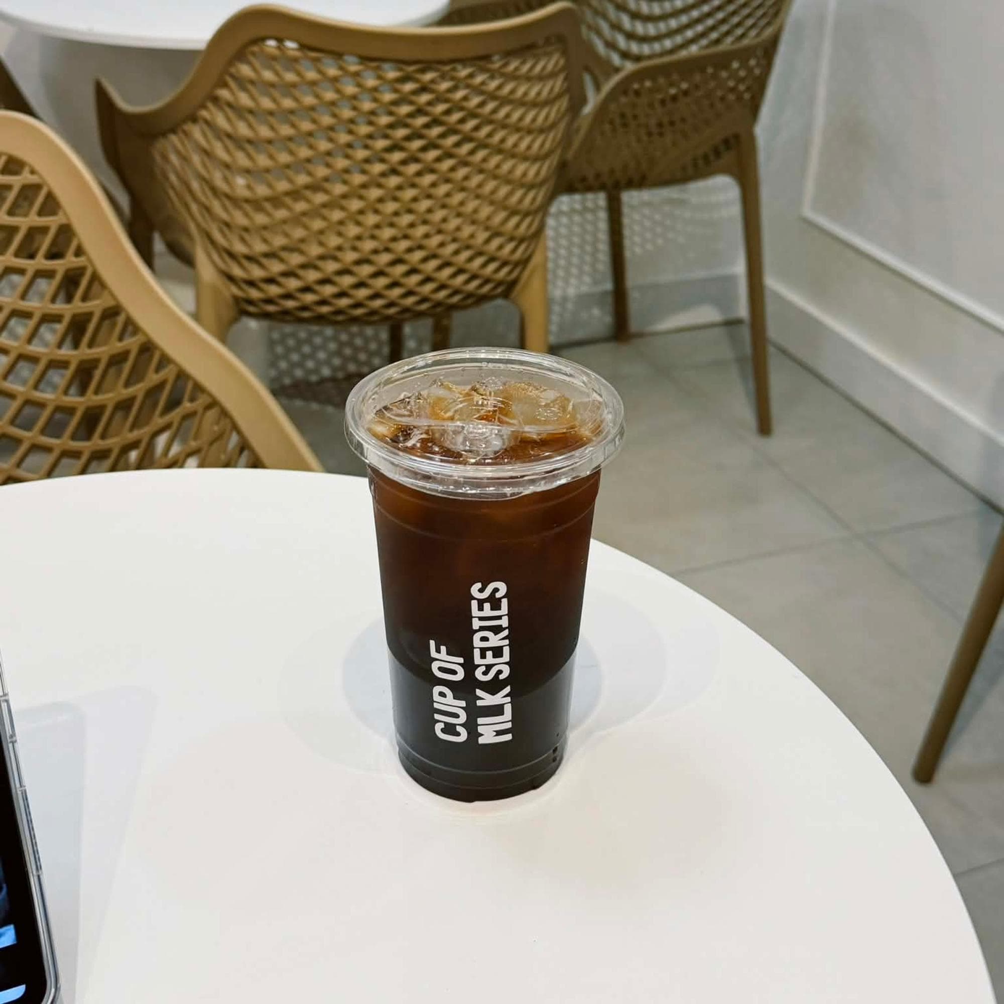 Iced coffee on a round cafe table inside Cup Of Mlk Series